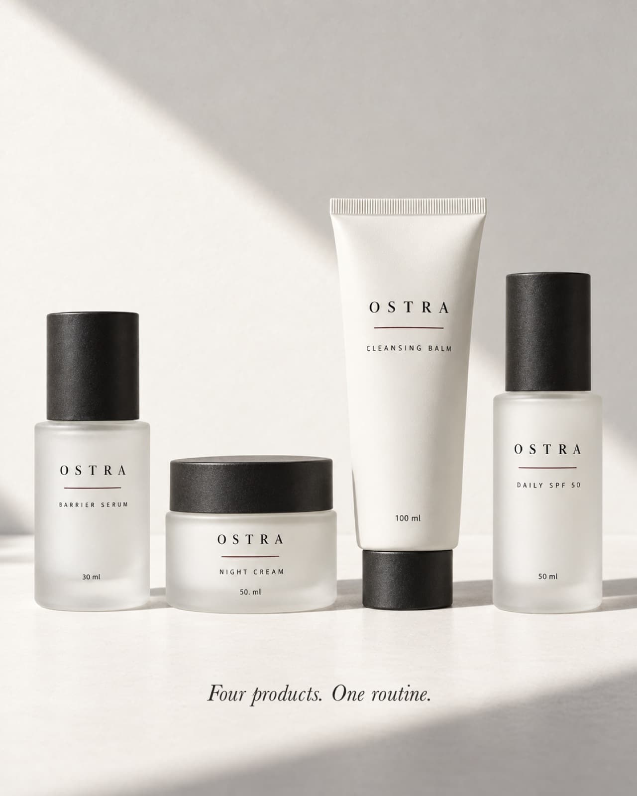 The four OSTRA products in a row on a porcelain surface: serum, night cream, cleansing balm and daily SPF