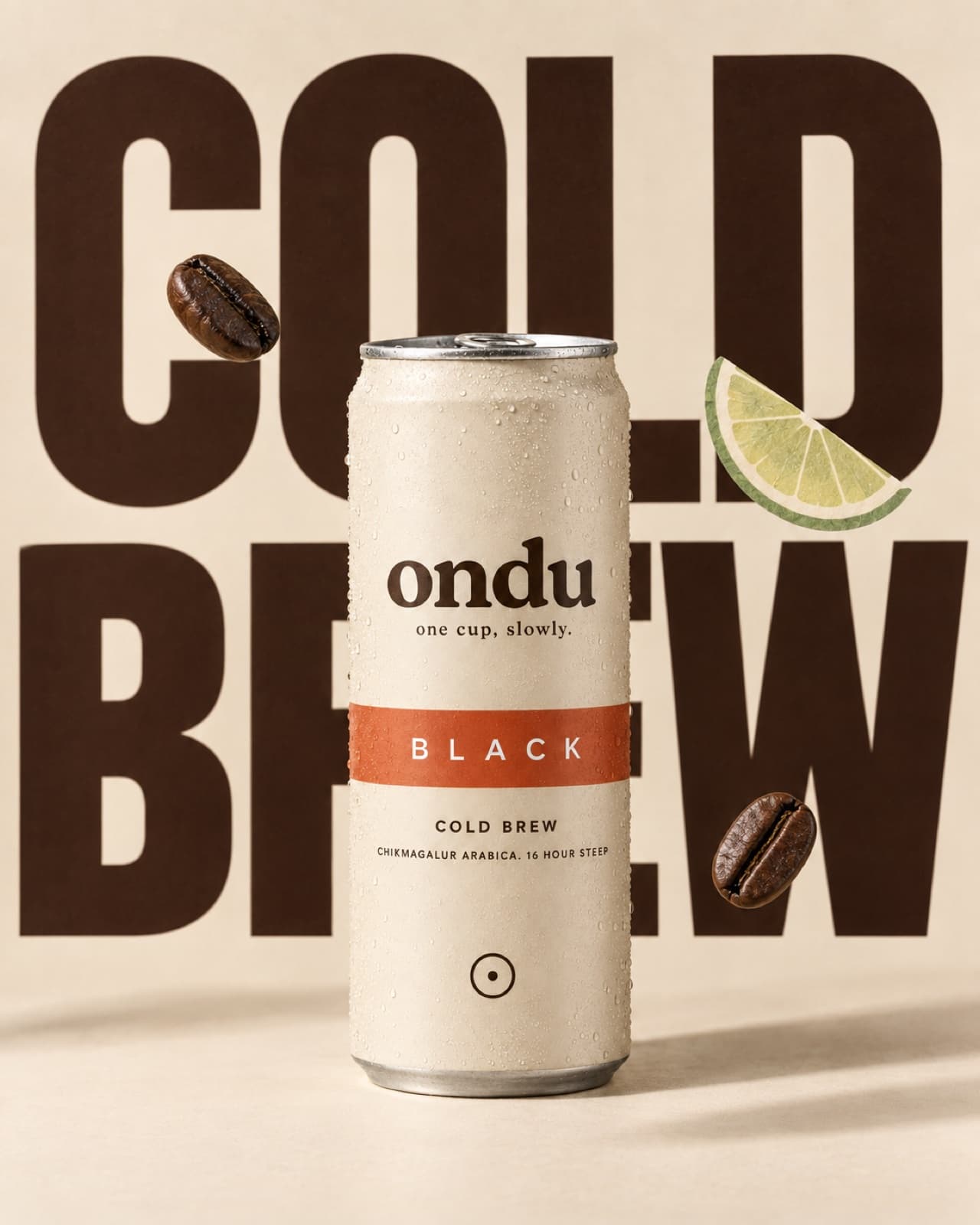 A cream ondu cold brew can standing in front of large espresso-coloured COLD BREW lettering, with coffee beans and a lime slice